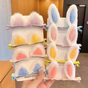 Close-up of plush cat and rabbit ear hair clips in pink, yellow, orange, and blue colors