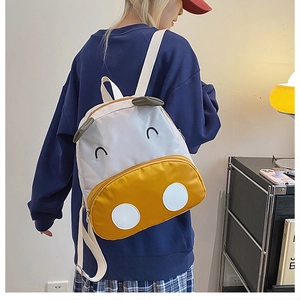 Detail of adjustable straps on cartoon cow toddler backpack in yellow and white canvas