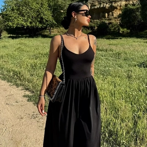 Detail of elegant black backless maxi dress in stretch fabric worn in an outdoor setting