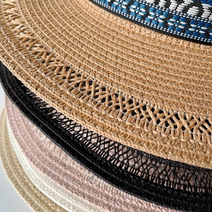Dettaglio di cappelli di paglia bohémien con motivi a trama cava e nastri a trama geometrica