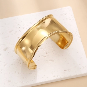 Detailed side view of 18k gold-plated cuff bracelet with mirror finish on white stone