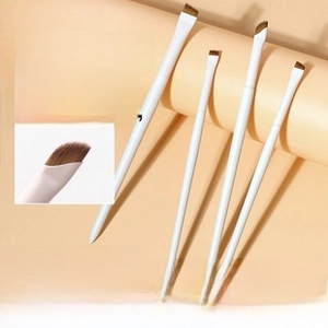 Detailed view of white angled eyeliner and eyebrow brushes with synthetic bristles