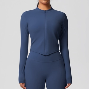 Détail d'une veste de yoga bleu foncé avec fermeture éclair et leggings de sport taille haute