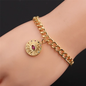 Detail of gold-plated evil eye bracelet with rainbow zircons on a model's wrist