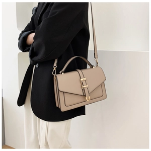 Detailed view of beige crossbody bag with top handle and adjustable shoulder strap