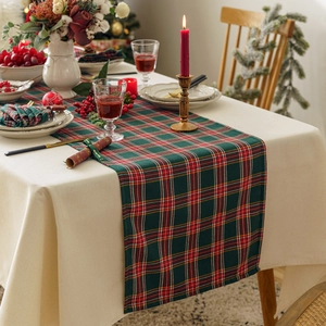 Classic red and green plaid Christmas table runner on a festive holiday dinner table setting
