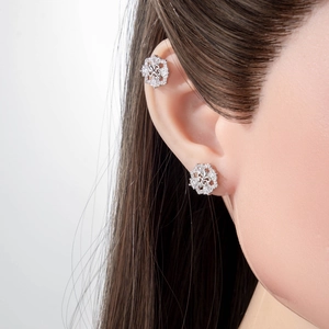 Elegant silver iris cross stud earrings and ear cuff with zircons worn by a model
