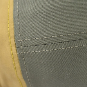 Detailed close-up of premium cotton twill stitching and khaki green fabric panels