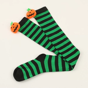 Close-up of Halloween striped over-knee socks with orange pumpkin plush charms