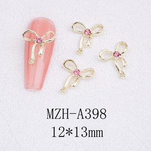 Macro detail of alloy bowknot nail charm with pink rhinestone for DIY manicure art