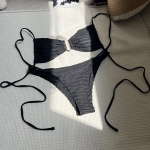 Detail of black seersucker bikini set with gold U-shaped metal buckle on the top