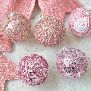 Detailed view of pink Christmas ball ornaments with embroidery, pearls and sequins on white fur