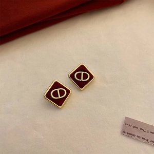 Macro shot of vintage diamond-shaped earrings with red finish and gold-tone metal hardware