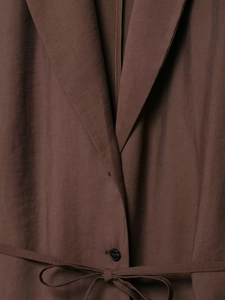 Detail of dark brown blazer featuring single-breasted buttons and adjustable waist belt