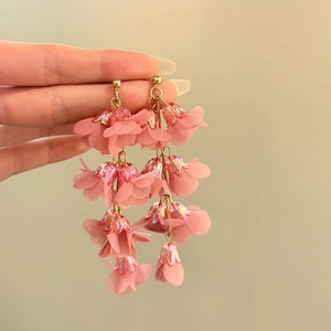 Close-up of pink lily of the valley tassel earrings with delicate fabric petals.