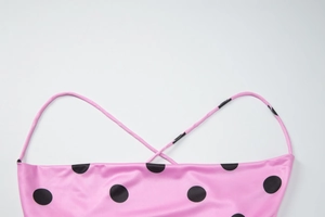 Détail de la robe en satin à pois roses avec fines bretelles croisées dans le dos