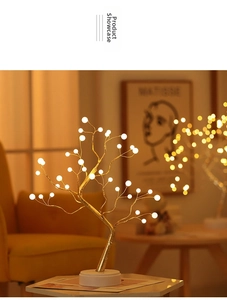Detail of warm white LED bonsai tree light with golden branches on a cozy table