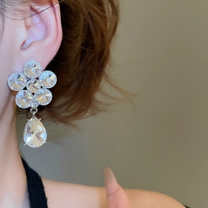 Macro shot of silver crystal flower earrings with a large pear-shaped water drop pendant
