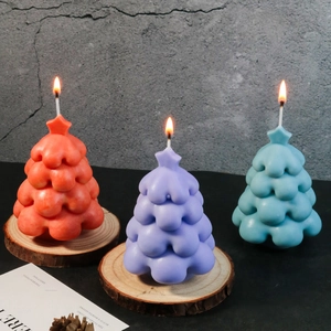 Detailed view of colorful Christmas tree candles with star tops on wooden bases