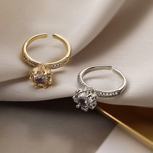 Luxurious gold and silver crown rings with sparkling zircon crystals on beige fabric
