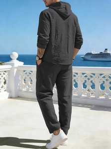 Detail view of the linen texture on a dark grey hooded tracksuit for men in a resort setting