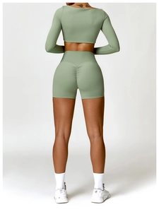 Detail view of sage green yoga set with high-waist scrunch butt shorts and long sleeve top