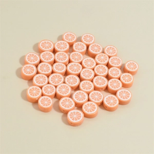 Macro detail of 10mm orange citrus polymer clay beads with white fruit slice patterns