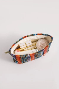 Detail of bohemian knitted cosmetic bag showing interior storage capacity and zipper closure