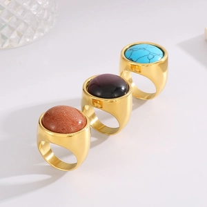 Detailed view of three 22mm gold stainless steel rings with colorful round gemstones