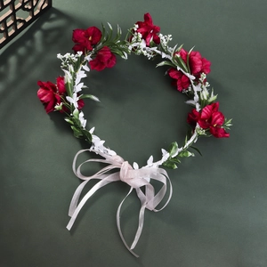 Close-up of handmade floral headband with red and white flowers and pink ribbon