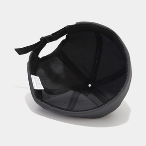 Minimalist black quick-dry polyester docker hat showing interior seams and buckle strap