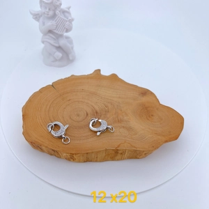 Macro shot of silver lobster clasps with micro-pave zircons on a wooden tray