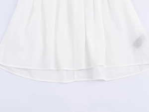 Close-up of the curved hemline and stitching on a white poplin shirt for women