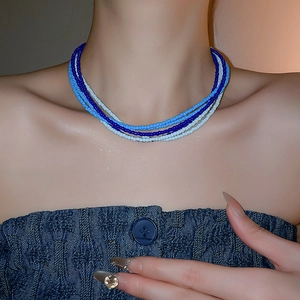 Detail of multi-layer blue seed bead necklace with bohemian style and layered design