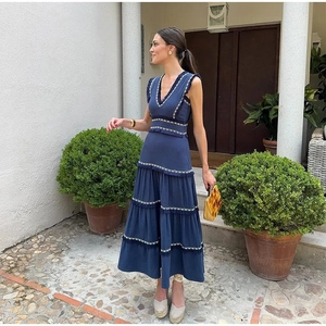 Détail d'une robe bleue sans manches à col en V avec broderie blanche et franges