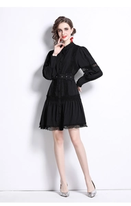 Detail of elegant black long sleeve dress featuring lace panels and a matching waist belt