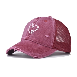 Detail of burgundy distressed trucker hat with heart paw embroidery and mesh back