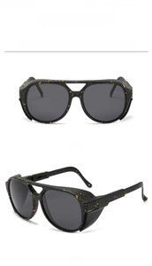 Detail of retro black double-bridge sunglasses with yellow splatter texture and side shields
