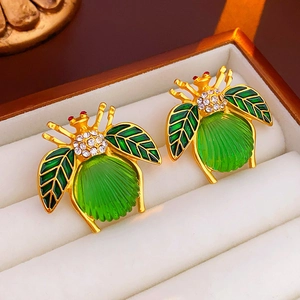 Vintage gold insect earrings with green gemstone and sparkling crystal wings in a gift box