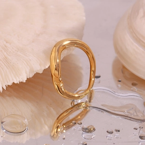 Close-up of 18K gold plated irregular ring on a mirror surface with water drops