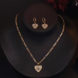 Gold plated heart evil eye necklace and earrings set on a black jewelry mannequin