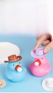 Detail of pink and blue toy ducks wearing mini rhinestone cowboy hats accessories