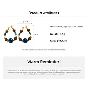 Detail view of hoop earrings featuring tiger eye stones and pearls with size specs