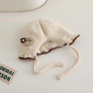 Detail showing waffle knit texture and flower embroidery on the baby winter hat