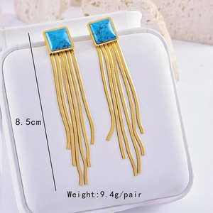 Detail of gold long tassel earrings featuring square turquoise stones and 8.5cm snake chains