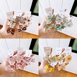 Close-up of assorted fabric bow hair ties in floral and plaid patterns with cards