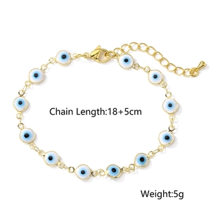 Golden Evil Eye bracelet with blue and white enamel beads on a white background