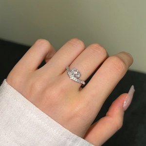 Macro detail of S-shaped silver ring band with round zircon stone on hand