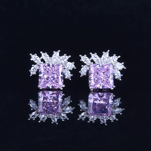 Macro view of silver stud earrings with purple radiant cut stone and marquise diamonds