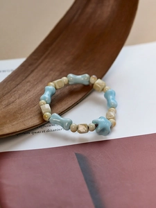 Detailed close-up of ceramic beaded bracelet with blue bone and beige cube beads